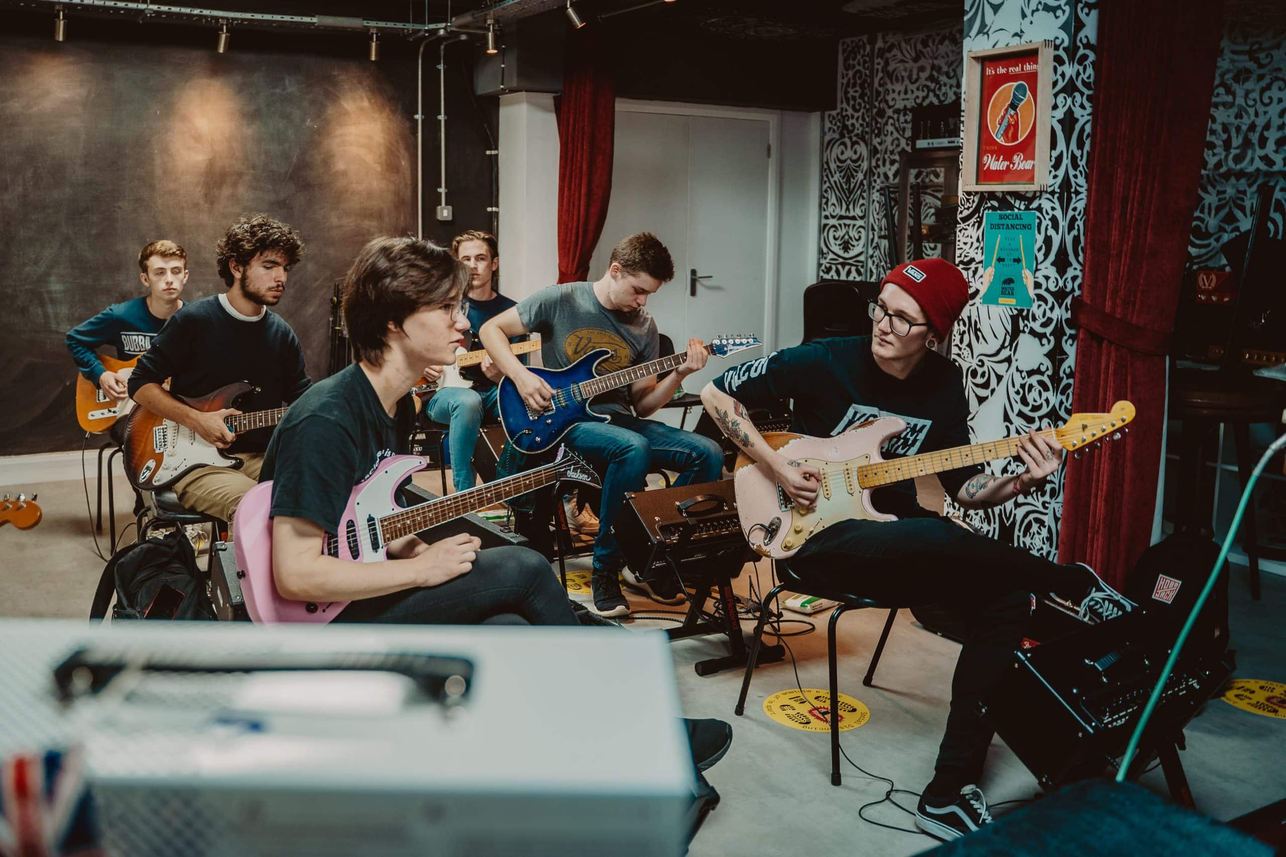 A guitar class at WaterBear, showing musicians playing guitar.
