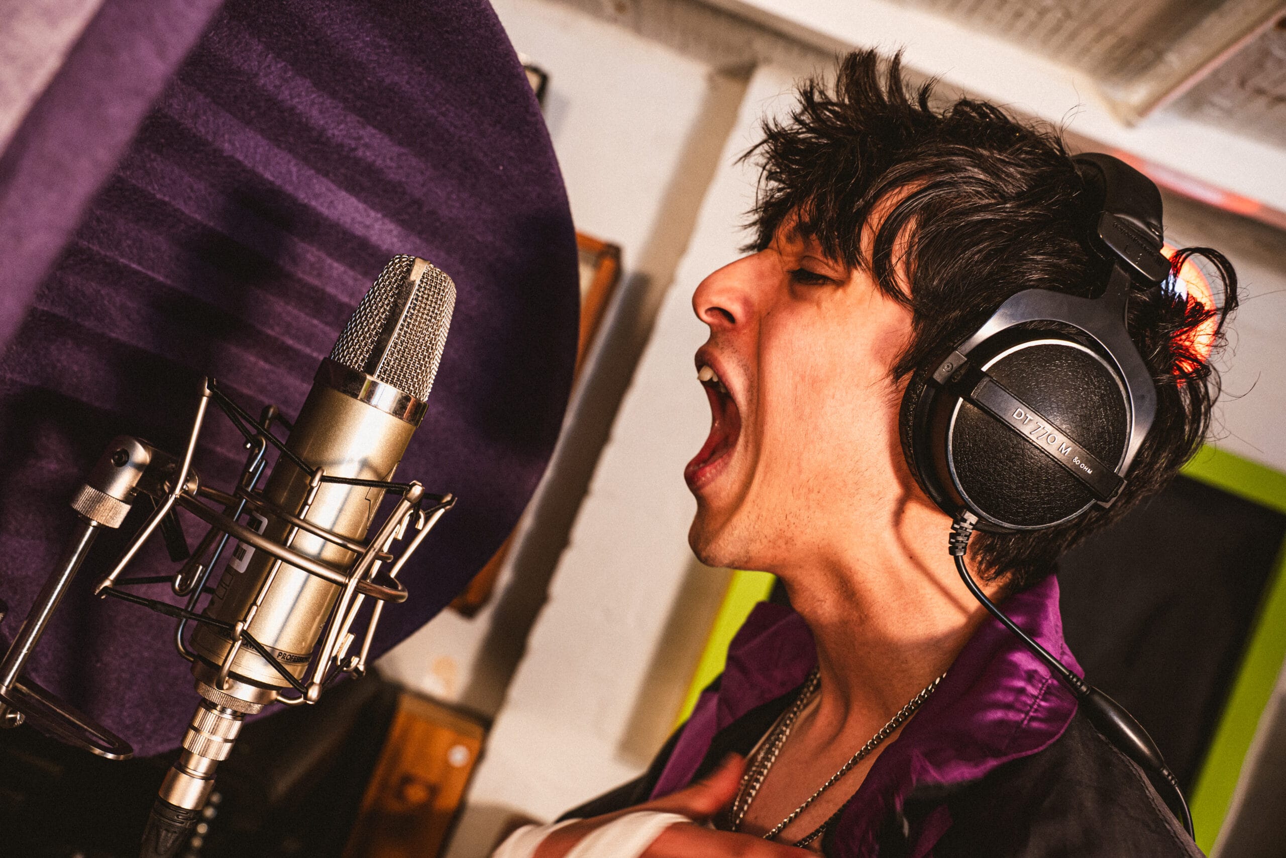 Independent artist recording vocals, demonstrating how to make music DIY on a budget.